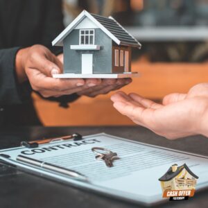 Person handing over a mini house figure, symbolizing the sale of a home - We Buy Houses Fast